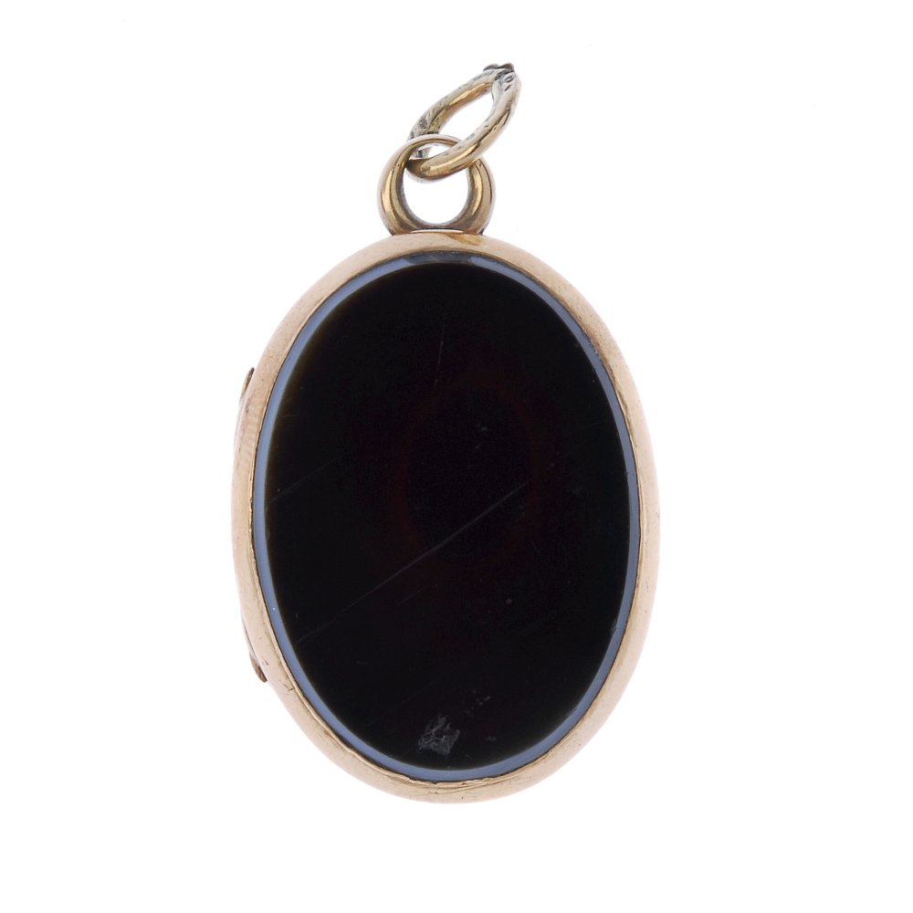 A late Victorian hard stone locket.: A late Victorian hard stone locket, circa 1870, of oval-shape outline, the onyx and carnelian panels, opening to reveal two vacant panels. Length 3.6cms. Weight 13.3gms.