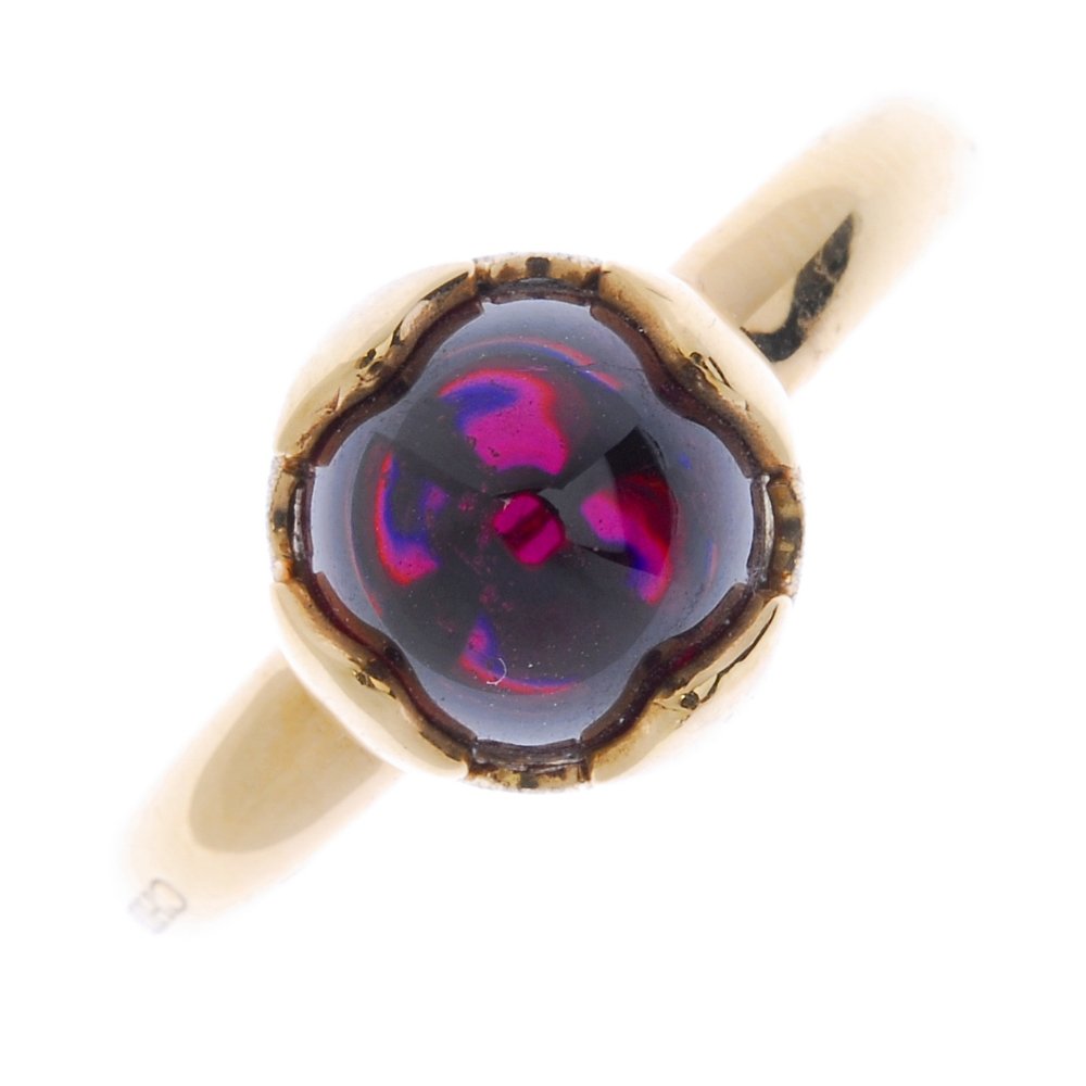 CHIMENTO - an 18ct gold garnet single-stone ring.: CHIMENTO - an 18ct gold garnet single-stone ring. The garnet cabochon, within a vari-texture petal surround, to the plain band. Signed Chimento. Hallmarks for Edinburgh. Weight 5.9gms.