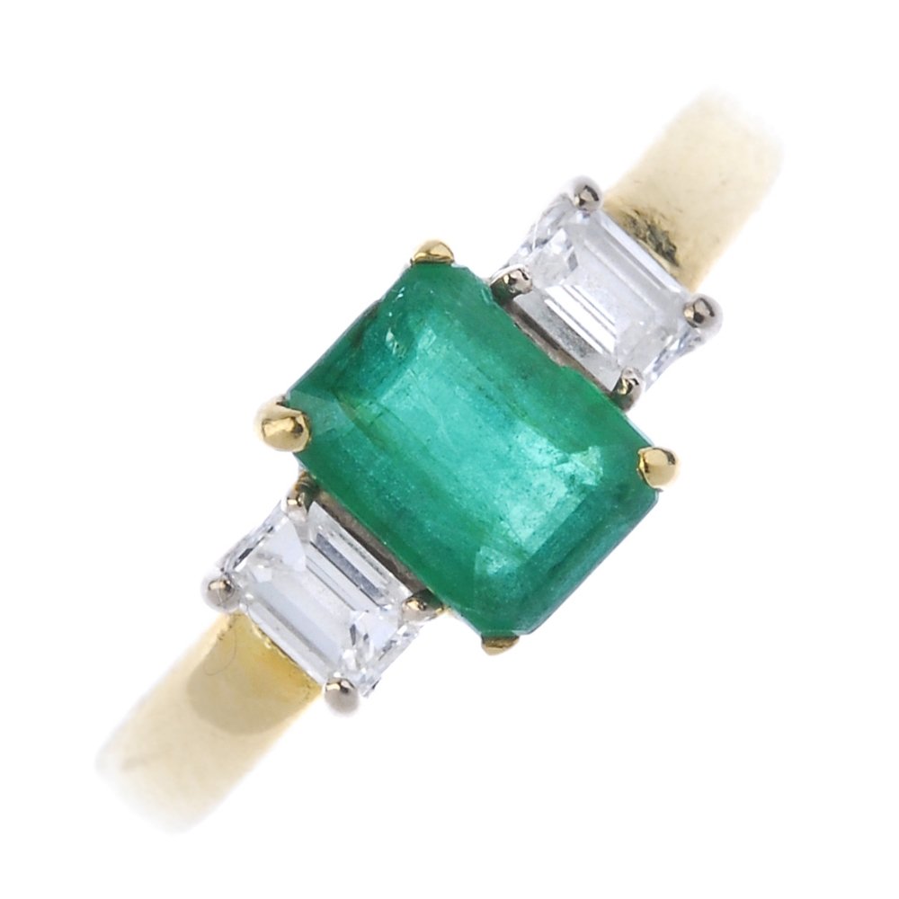 An 18ct gold emerald and diamond three-stone ring. (1 of 3)