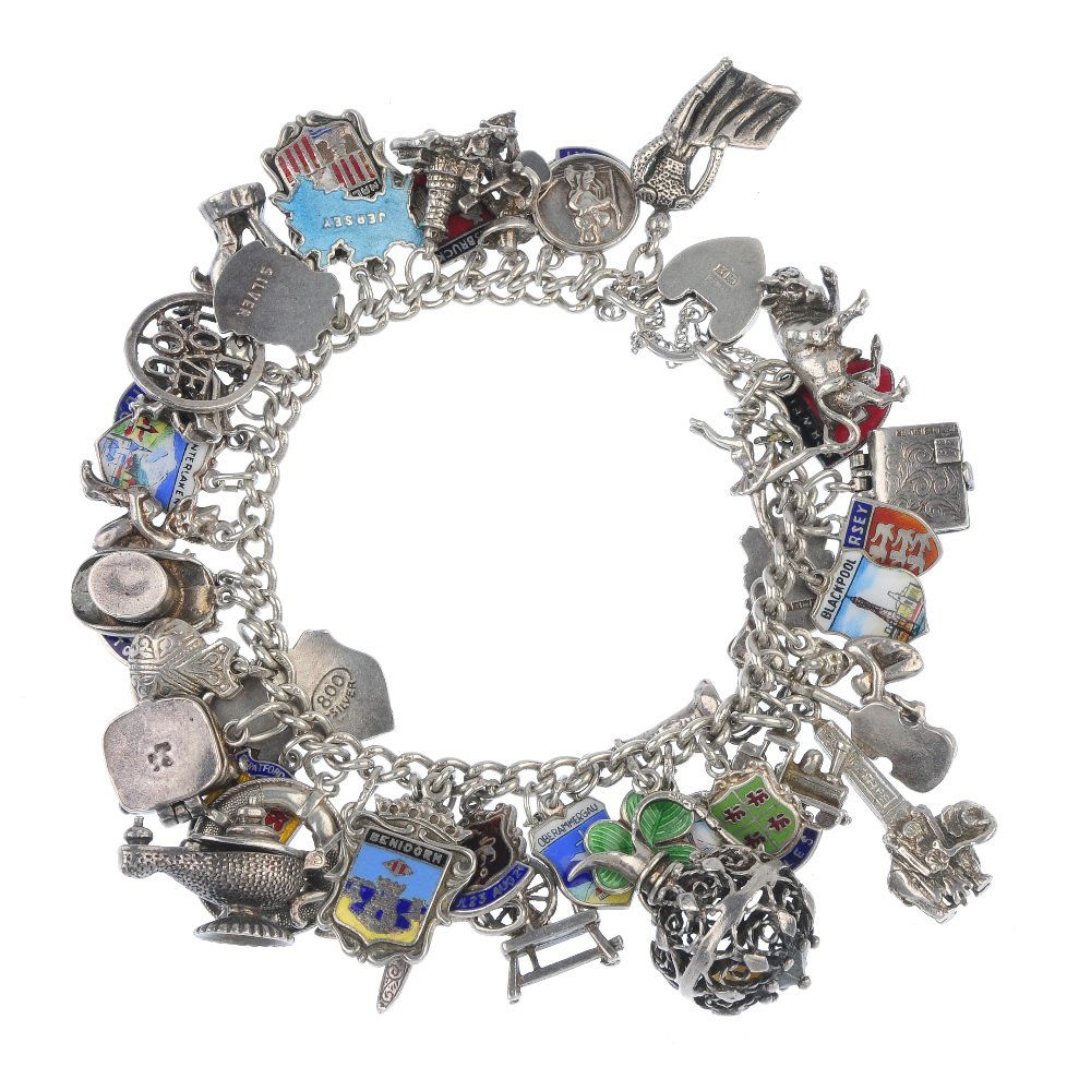 Two silver and white metal charm bracelets.: Two silver and white metal charm bracelets. The curb-link chains, suspending a total of sixty-eight charms, to include a Holy Bible, a typewriter and a pair of castanets. Most with marks to indicate s