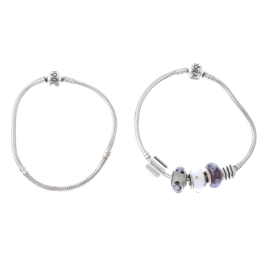 PANDORA - two charm bracelets.: PANDORA - two charm bracelets. With five Pandora charms including three glass charms, a snake and a scroll reading 'Forever Together'. With maker's marks. Lengths 19 to 20cms. Weight 47.6gms.