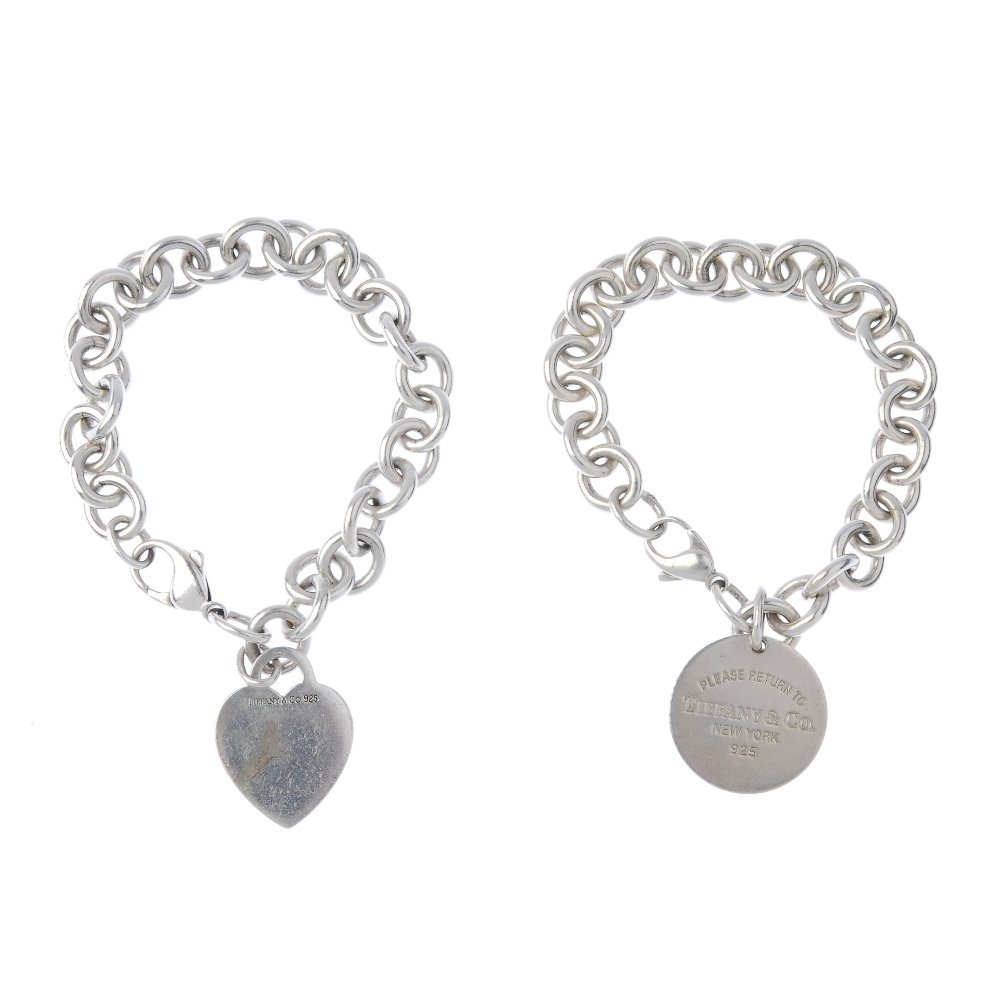 TIFFANY & CO. - two bracelets.: TIFFANY & CO. - two bracelets. Both designed as belcher-link bracelets one suspending a heart-shape 'Please return to Tiffany' charm, the other a circular charm of similar design. Signed Tiffany & Co.
