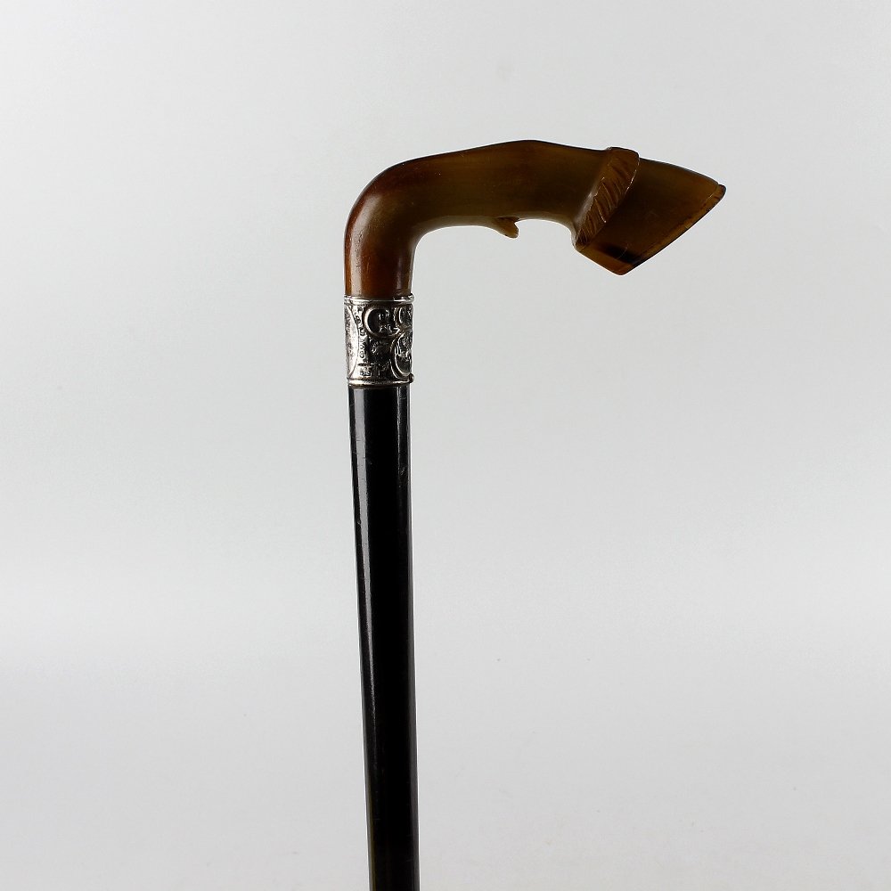 A late Victorian silver-mounted horn-handled treen: A late Victorian silver-mounted horn-handled treen walking stick or cane. The horse hoof-form handle over silver collar hallmarked London, 1892, maker's mark indistinct, to a tapering shaft with brass
