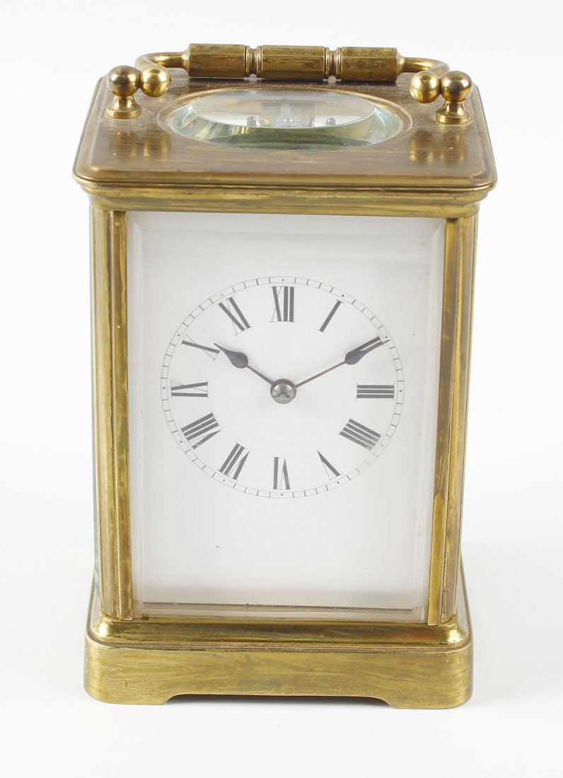 A two-train carriage clock: A brass cornice cased carriage clock with white Roman dial, the replaced leaver platform escapement striking on a coiled gong, 5.25" (13.5cm) high excluding handle.
