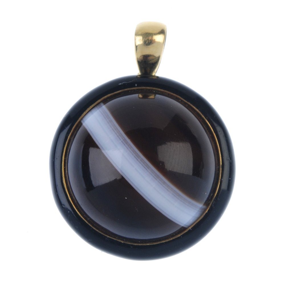 A banded agate pendant and earring.: A banded agate pendant and earring. The pendant designed as a circular banded agate cabochon, within a black enamel surround, together with a matching earring. Lengths 2.4 and 3.1cms.