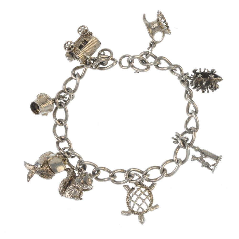 Two charm bracelets.: Two charm bracelets. Both designed as curb-link chains, suspending a total of fourteen charms, to include a snake charmer and a squirrel. Lengths 17 to 18cms. Weight 88.4gms. Some AF.