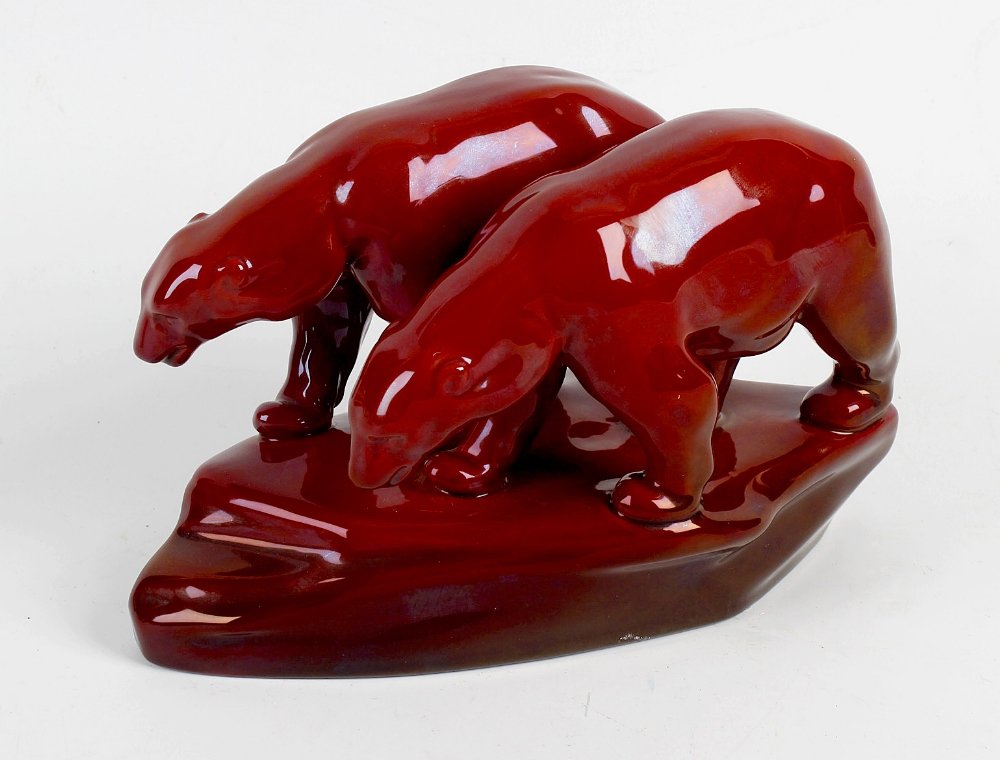 A Zsolnay Pecs flambe polar bear group. Modelled as two: A Zsolnay Pecs flambe polar bear group. Modelled as two bears standing upon a naturalistic base, 7.5 long x 4.75 high, (19cm x 12cm).
