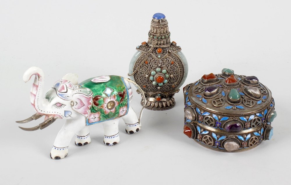 Five Eastern cabinet items. Comprising: a carved: Five Eastern cabinet items. Comprising: a carved soapstone group modelled as two shishi or Dogs of Fo flanking a pierced puzzle ball; a white metal snuff bottle with assorted cabochons a filigree work