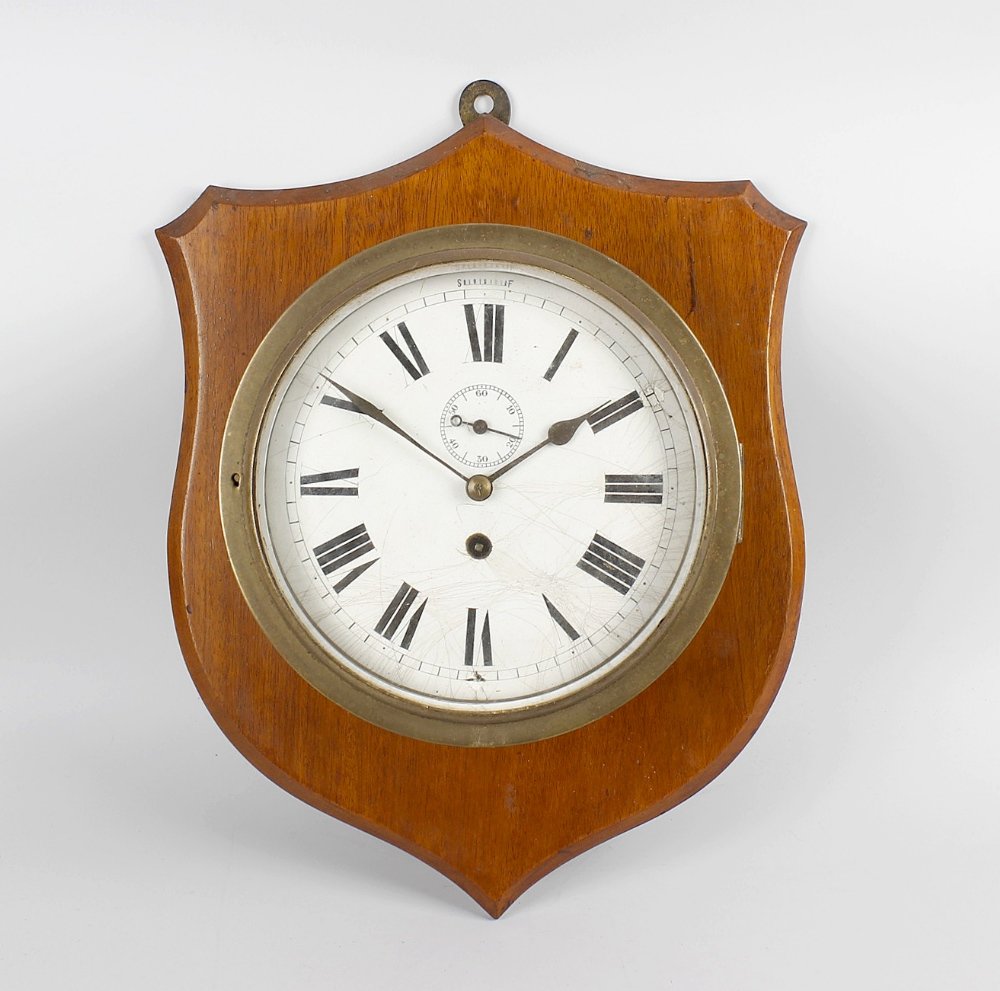 A late 19th century brass cased ships bulkhead style: A late 19th century brass cased ships bulkhead style clock, the bevel edged circular glass door, enclosing a white circular dial with black Roman numerals, divisions and shaped hands, dial 7.5 (19cm)
