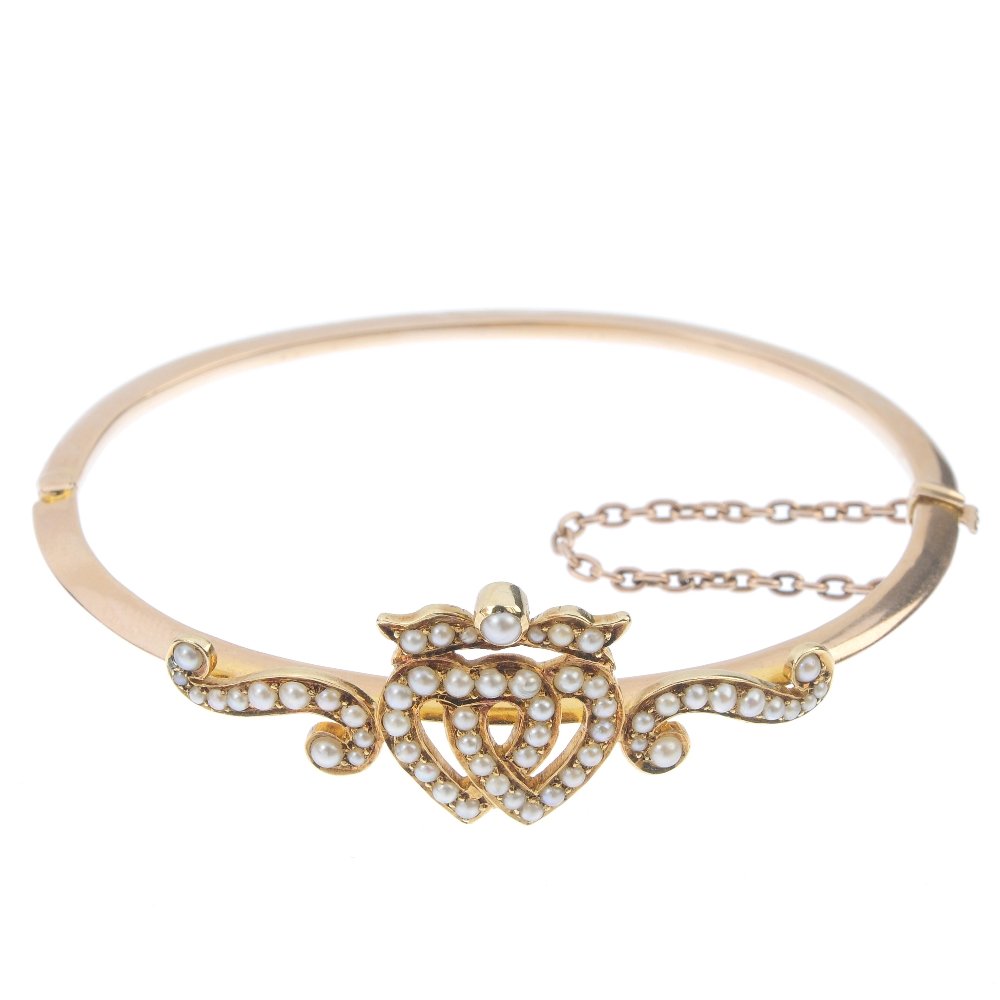 A late 19th century gold split pearl hinged bangle. The (1 of 2)