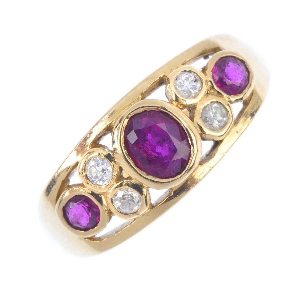 An 18ct gold ruby and diamond dress ring. The oval and (1 of 3)