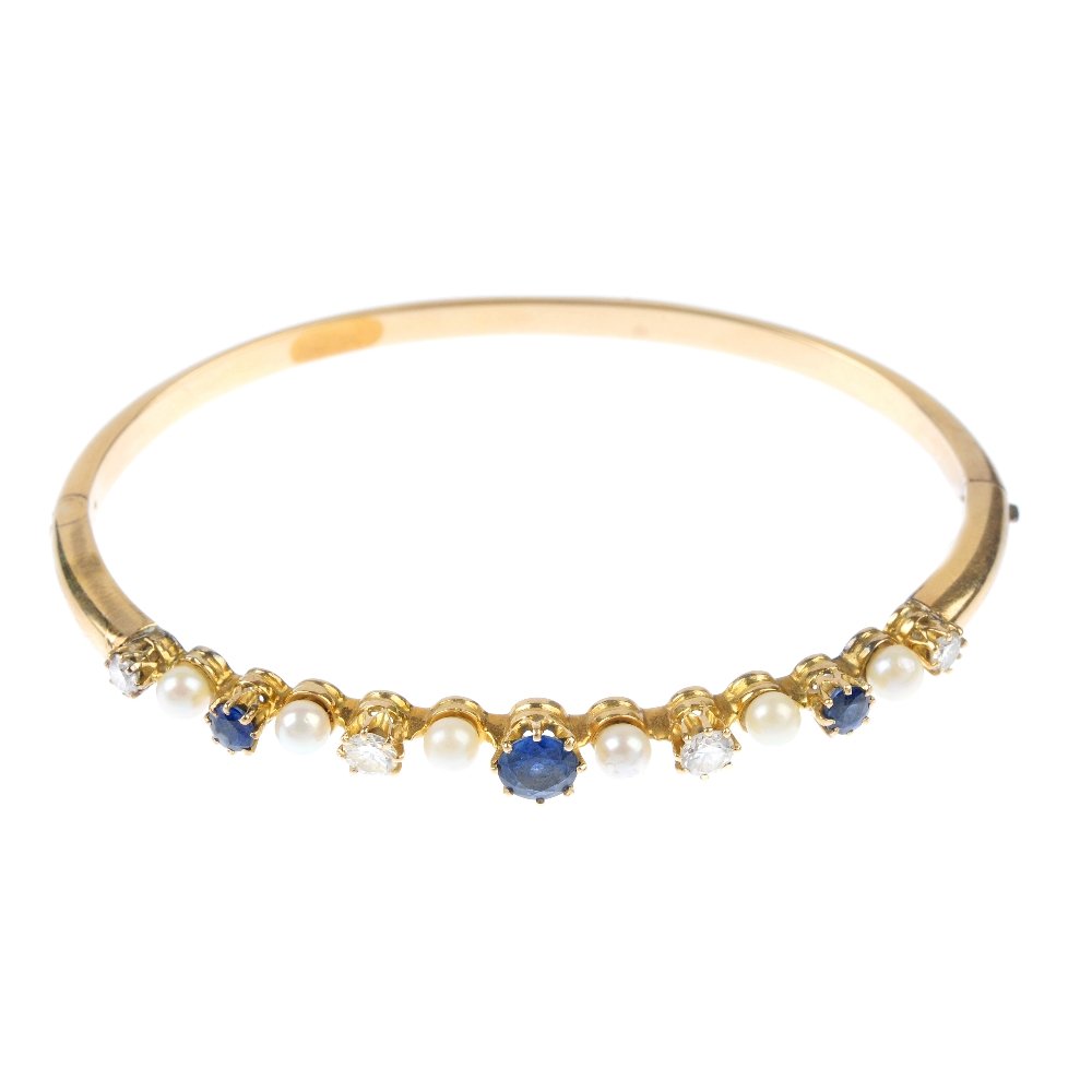 A diamond, sapphire and seed pearl bangle. The (1 of 3)