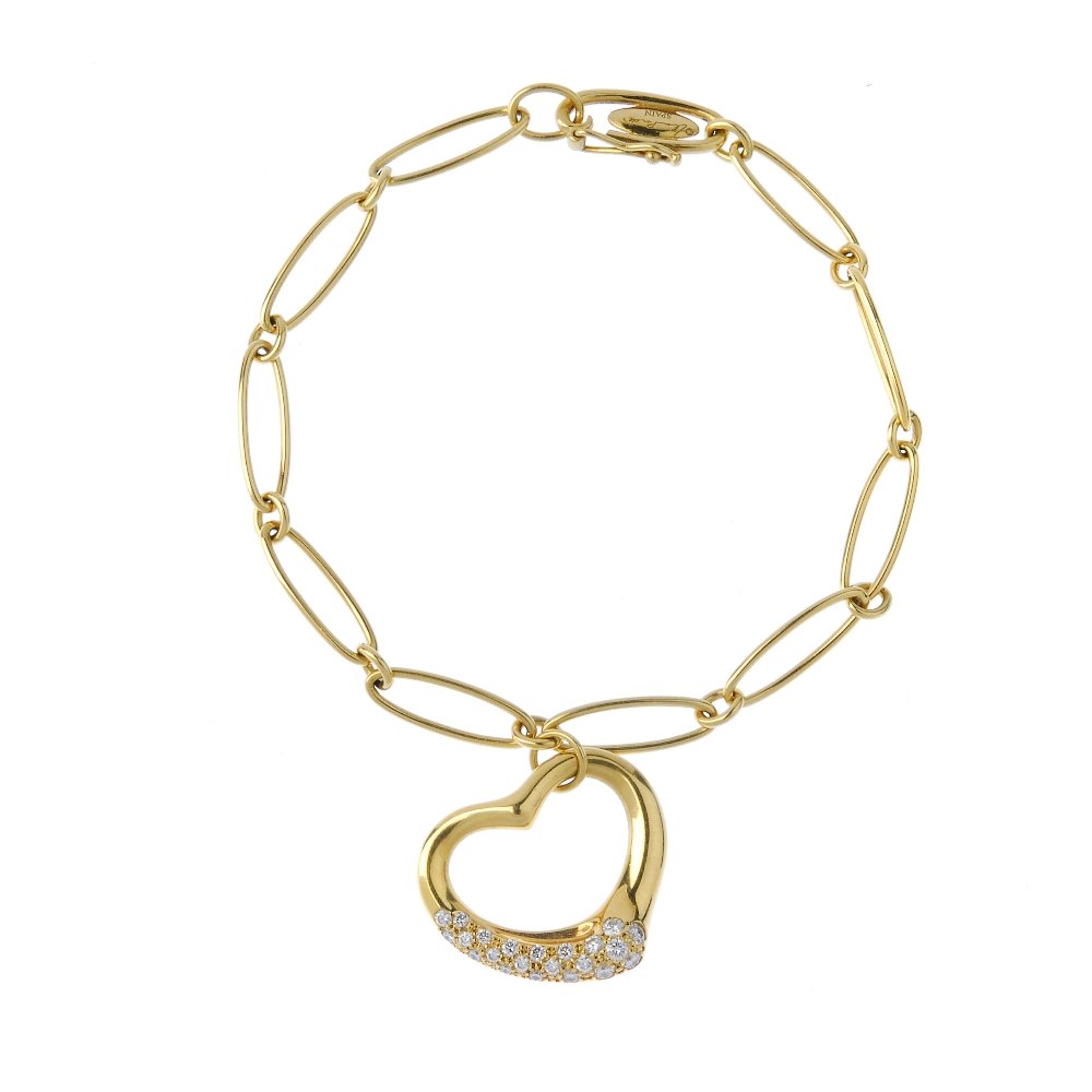 TIFFANY & CO. - a diamond 'open heart' bracelet by Elsa: TIFFANY & CO. - a diamond 'open heart' bracelet by Elsa Perretti. The 18ct gold heart charm with brilliant-cut diamond highlight, suspended from a trace-link chain. Signed Tiffany&Co. with facsimile s