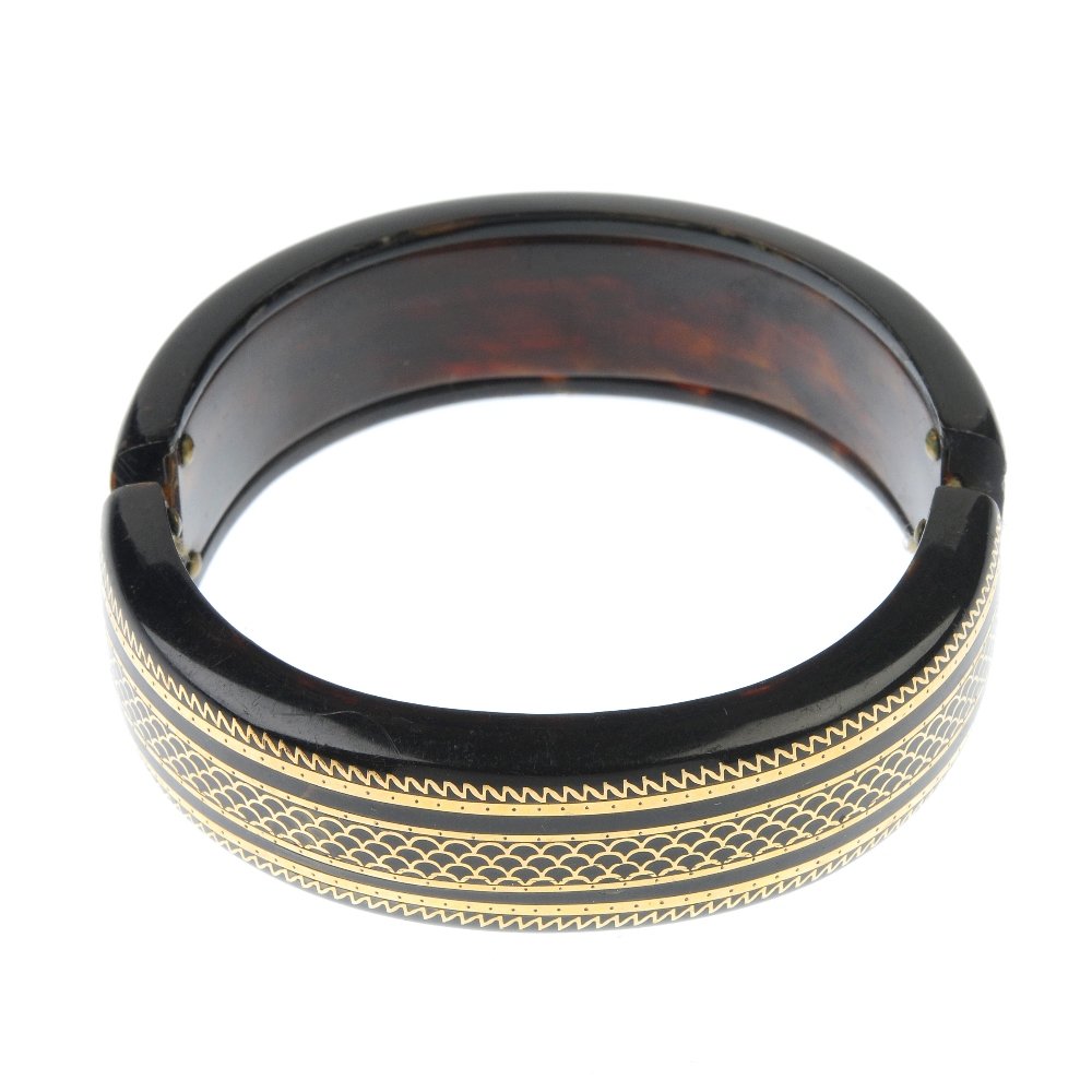 A late 19th century tortoiseshell pique bangle. The (1 of 2)