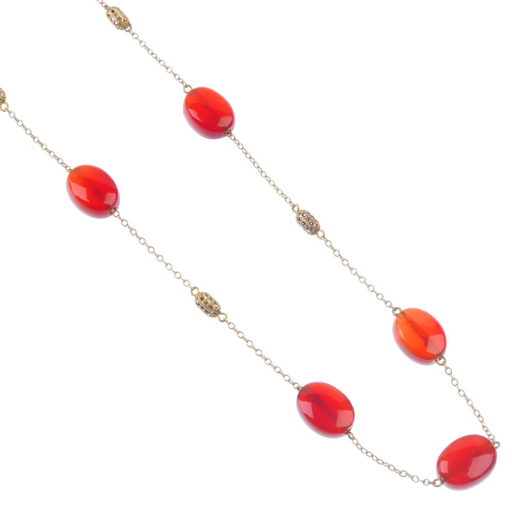 An early 20th century gold carnelian necklace. The: An early 20th century gold carnelian necklace. The seven flat oval-shape beads set to a belcher link chain with four openwork stations between. Length 38cms. Weight 11.6gms. The condition of this lot 