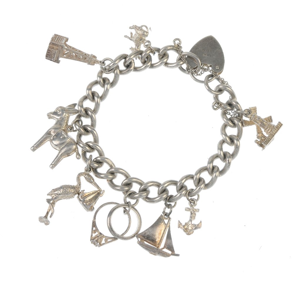 Two charm bracelets. The two curb-link chains: Two charm bracelets. The two curb-link chains suspending a total of fifteen charms including a boot and a donkey. Lengths 16 to 18cms. Weight 73.8gms. This lot is in fair condition, with scratches, di