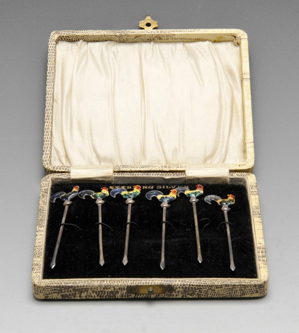 A cased set of six cocktail sticks marked 'sterling: A cased set of six cocktail sticks marked 'sterling silver', each with enamelled cockerel finial. Together with a cased pair of plated fish servers, cased fruit knives and forks with mother-of-pearl h