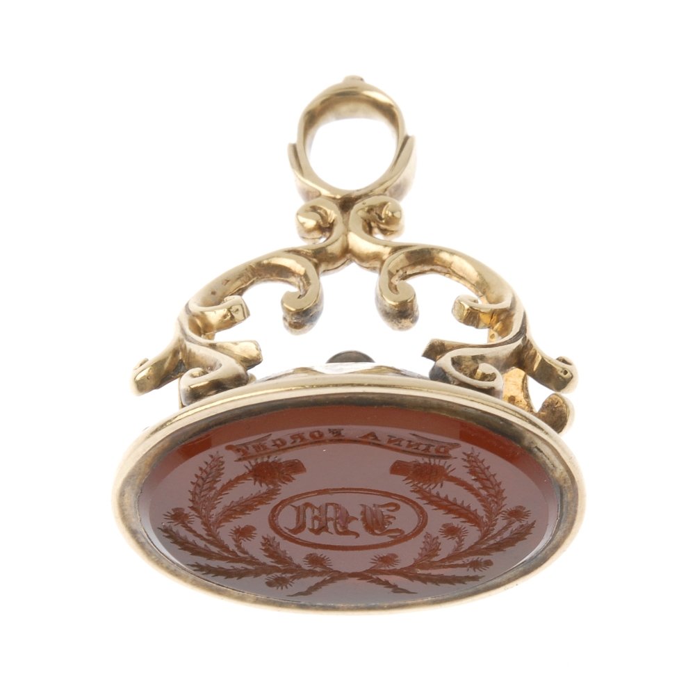 A late 19th century gold hardstone fob seal. The: A late 19th century gold hardstone fob seal. The oval-shape carnelian, with engraved monogram within a thistle wreath and 'Dinna Forget' ribbon, to the scrolling foliate surmount. Length 2.7cms. Weigh