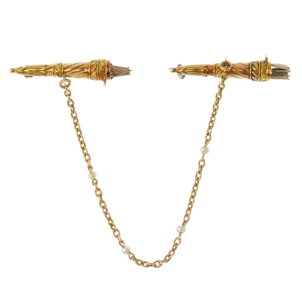 A late 19th century gold bow and arrow cloak fastener.: A late 19th century gold bow and arrow cloak fastener. Of tri-colour design, the quivers each engraved with a scrolling and foliate motif, to the series of fletchings and connecting trace-link chain w