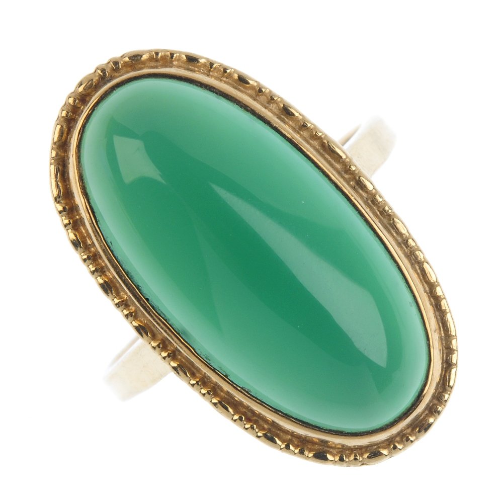 A 9ct gold dyed chalcedony ring. The oval dyed: A 9ct gold dyed chalcedony ring. The oval dyed chalcedony cabochon, within a textured border. Hallmarks for Birmingham, 1979. Ring size Q. Weight 6.3gms. Overall condition good. Minor surface scratche
