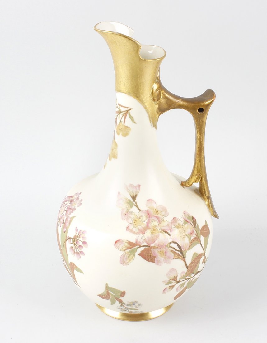 A large Royal Worcester porcelain jug, of shouldered: A large Royal Worcester porcelain jug, of shouldered pear form having a capped handle, sparsely decorated with various flowers upon a cream glaze ground, marked and numbered beneath, 13 (33cm) high. W