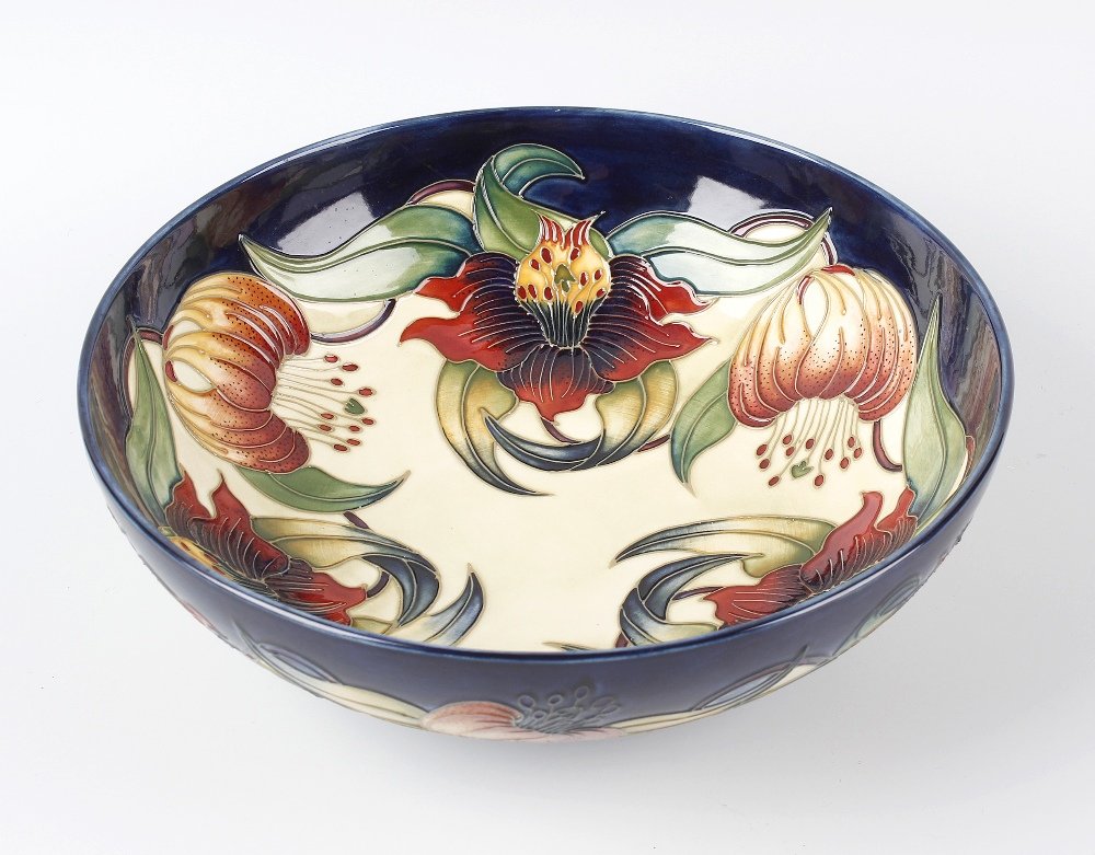 A modern Moorcroft pottery Anna Lily pattern bowl, of: A modern Moorcroft pottery Anna Lily pattern bowl, of circular form with tune-lined flowers on a split blue and cream glaze ground, impressed and painted marks including initials AJF and SF beneath, 1