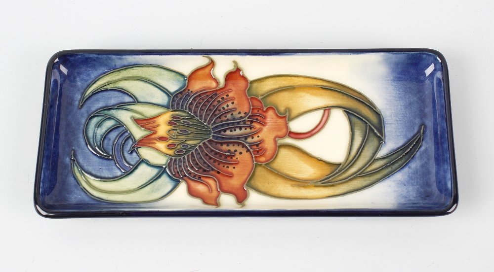 A modern Moorcroft pottery Anna Lily pin tray, of: A modern Moorcroft pottery Anna Lily pin tray, of rectangular form with an orchid on a merging blue and cream glaze ground, impressed and painted marks including initials NW beneath, 8, (20.5cm) long.