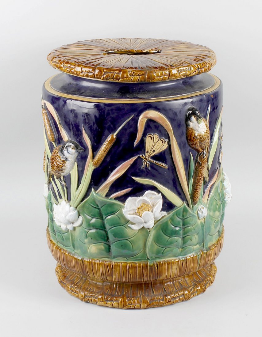 A George Jones type majolica pottery garden seat, of: A George Jones type majolica pottery garden seat, of barrel shape, the top with pierced aperture forming a carry handle, modelled as faux woven rushes, the moulded sides decorated with birds and drago