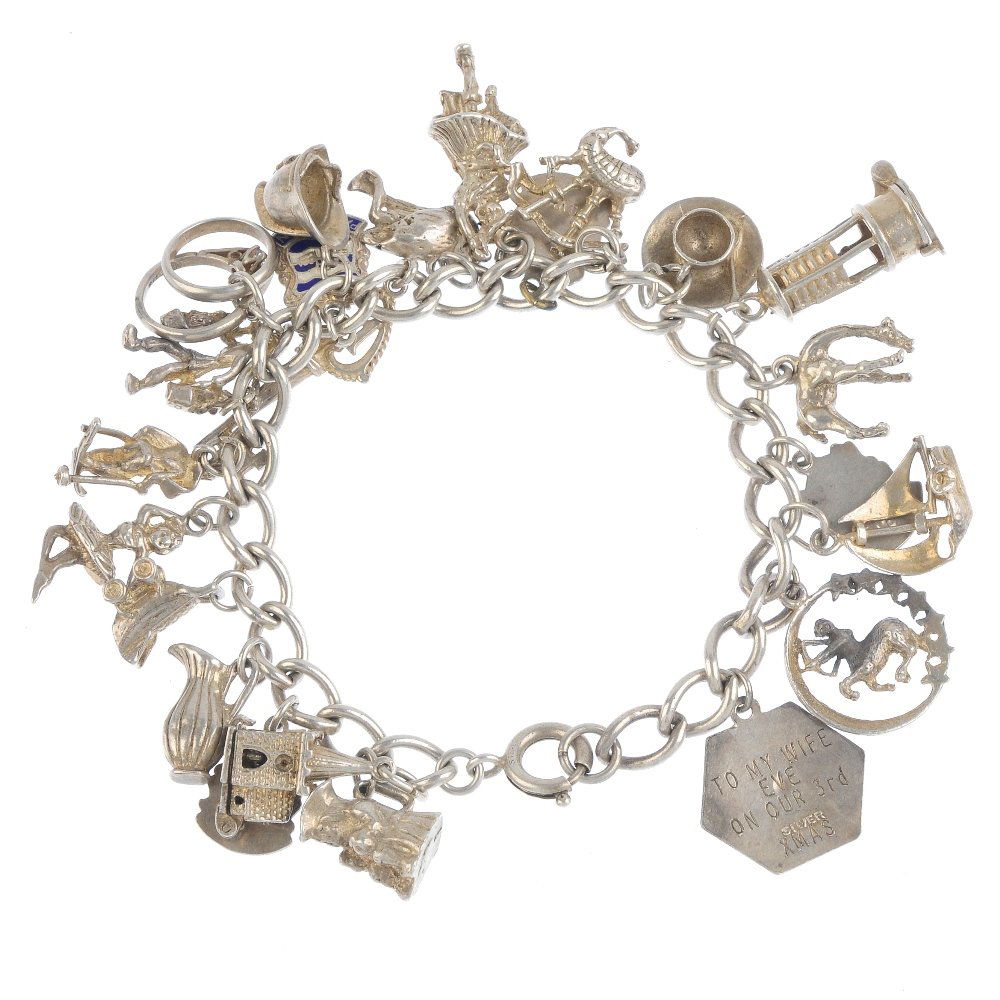 Two charm bracelets. The two curb-link bracelets: Two charm bracelets. The two curb-link bracelets suspending a total of thirty-one charms, including the Statue of Liberty and a ballerina. Lengths 18.5 to 19cms. Weight 117.5gms.
