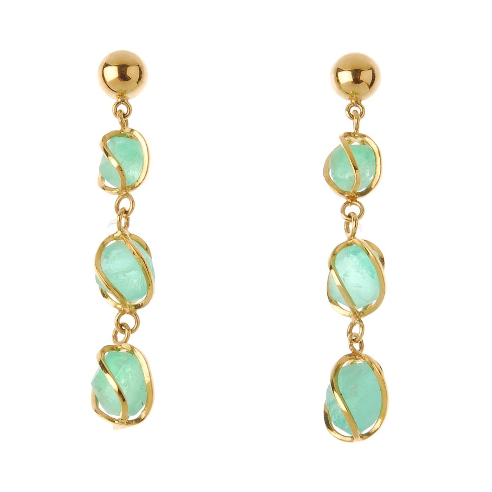 A pair of emerald earrings. Each designed as a: A pair of emerald earrings. Each designed as a free-from emerald line drop, each within a spiral surround. Length 4.2cms. Weight 4.8gms. Overall condition good. Minor surface scratches/wear in keeping
