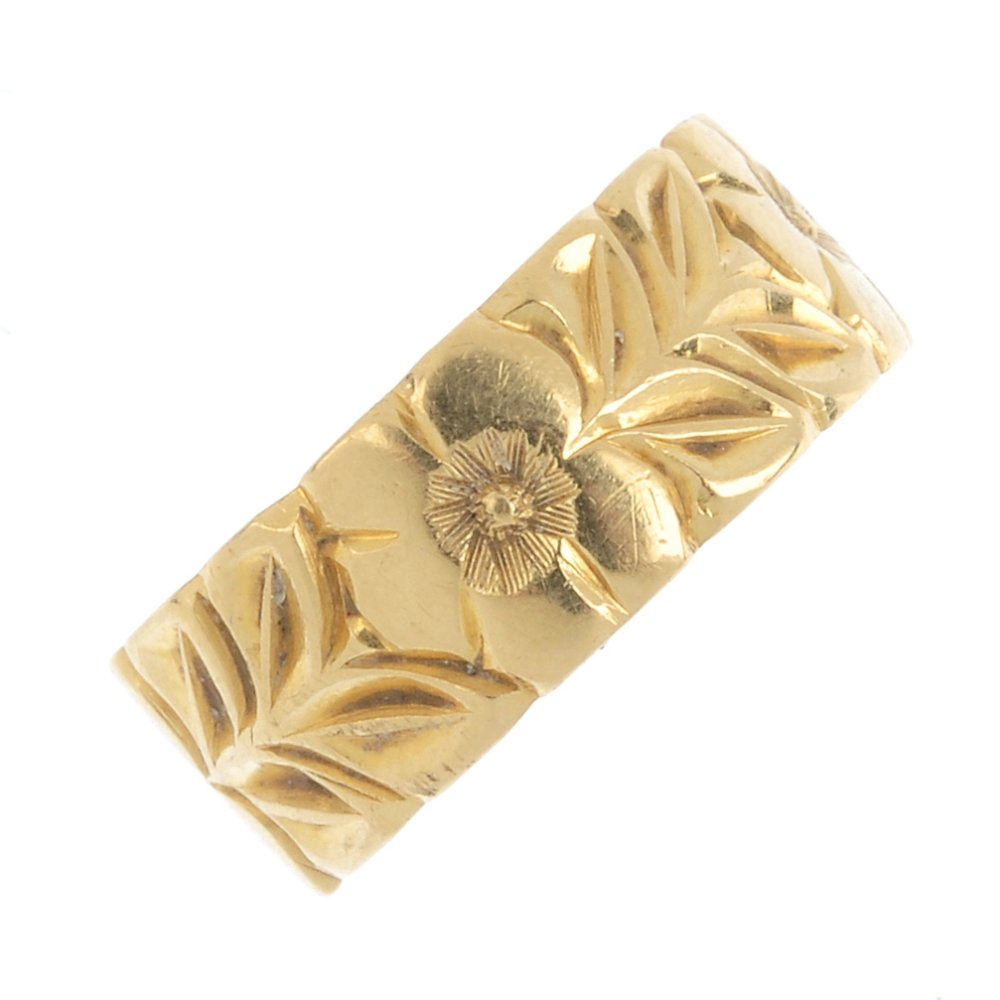 An 18ct gold band ring. Of floral embossed design. (1 of 2)