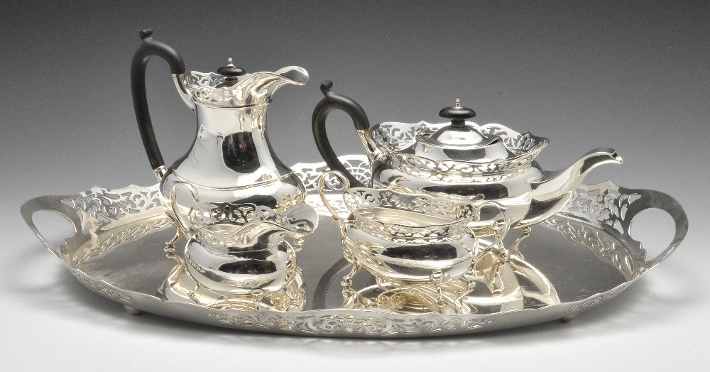 A 1930's four piece silver tea service and tray, each: A 1930's four piece silver tea service and tray, each piece of bellied oval form with scroll pierced gallery and standing on four hoof style feet. The tea service marked sterling silver 925, the tray 