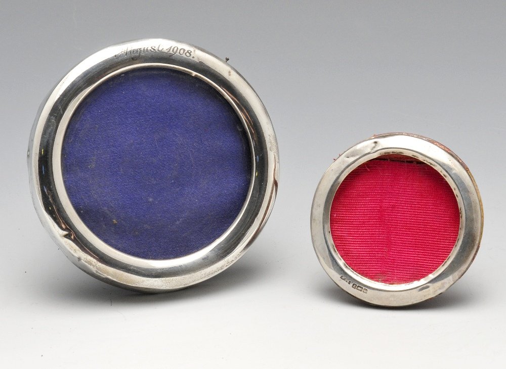 An Edwardian silver mounted photograph frame, of plain: An Edwardian silver mounted photograph frame, of plain circular form having date engraving, hallmarked William Comyns & Sons, London 1907, outer diameter measures 3 6/8 inches (9.5 cm). Together with