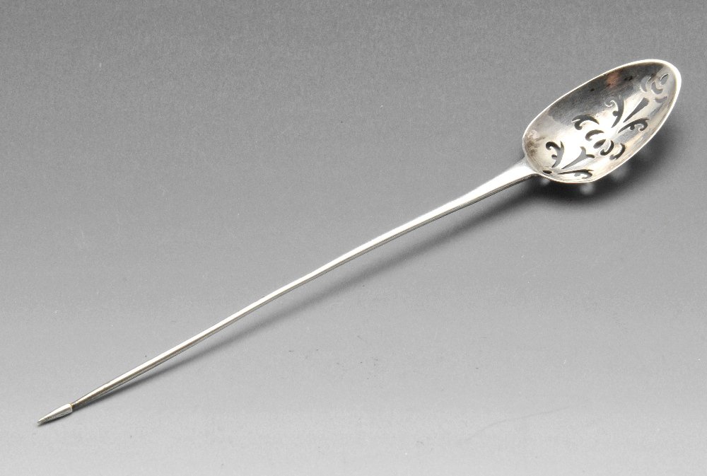 An eighteenth century silver mote spoon of typical form: An eighteenth century silver mote spoon of typical form with scroll pierced bowl, initial engraving to the heel and tapered stem. Lion passant only. Length measuring 6 inches, weight 6.7 grams.