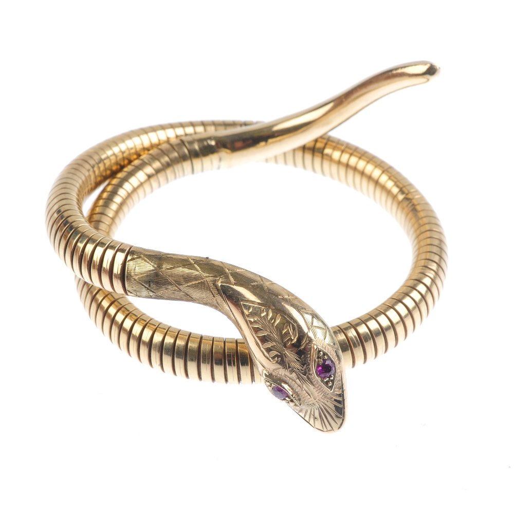 A 9ct gold snake bangle. Designed as an engraved snake (1 of 3)
