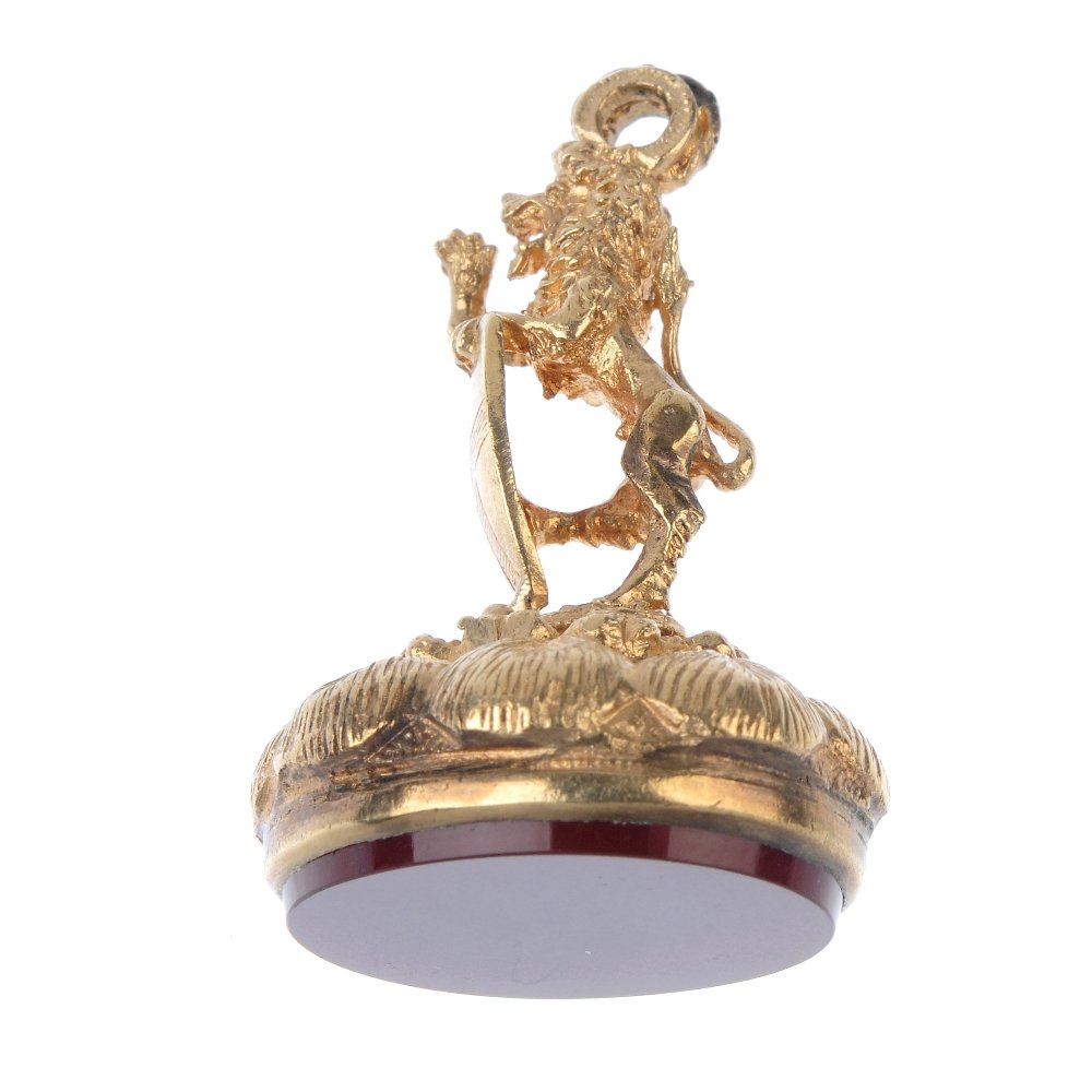 A fob. The blank carnelian panel to the feather design: A fob. The blank carnelian panel to the feather design pedestal with lion rampant to the top, holding a shield. Length 3.7cms. Weight 14.1gms. The condition of this lot is good, with light surface scr