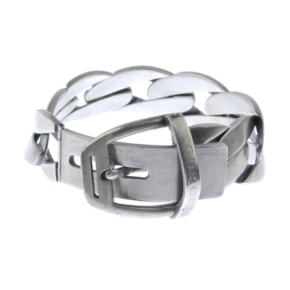 GUCCI - a bracelet. In the style of a flat curb-link: GUCCI - a bracelet. In the style of a flat curb-link chain, with buckle fastening. Signed Gucci. Length 21cms. Weight 75.5gms.