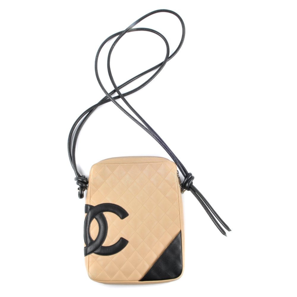 CHANEL - a Ligne Cambon crossbody bag. Designed with a: CHANEL - a Ligne Cambon crossbody bag. Designed with a cream quilted leather exterior and black leather trim, interlocking CC logo to one side, rear patch pocket, long double black leather cord crossb