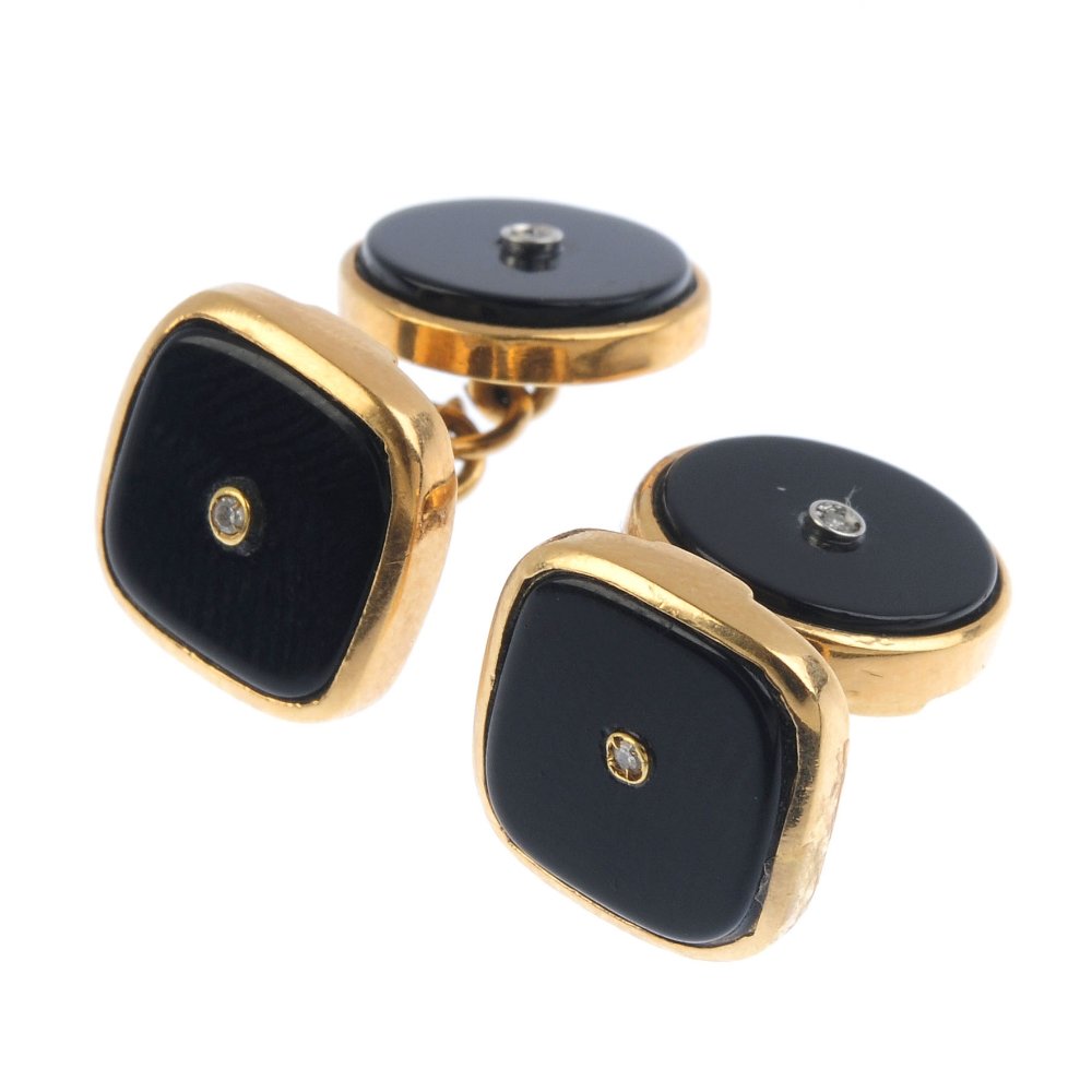 A pair of onyx and diamond cufflinks. Each designed as (1 of 1)