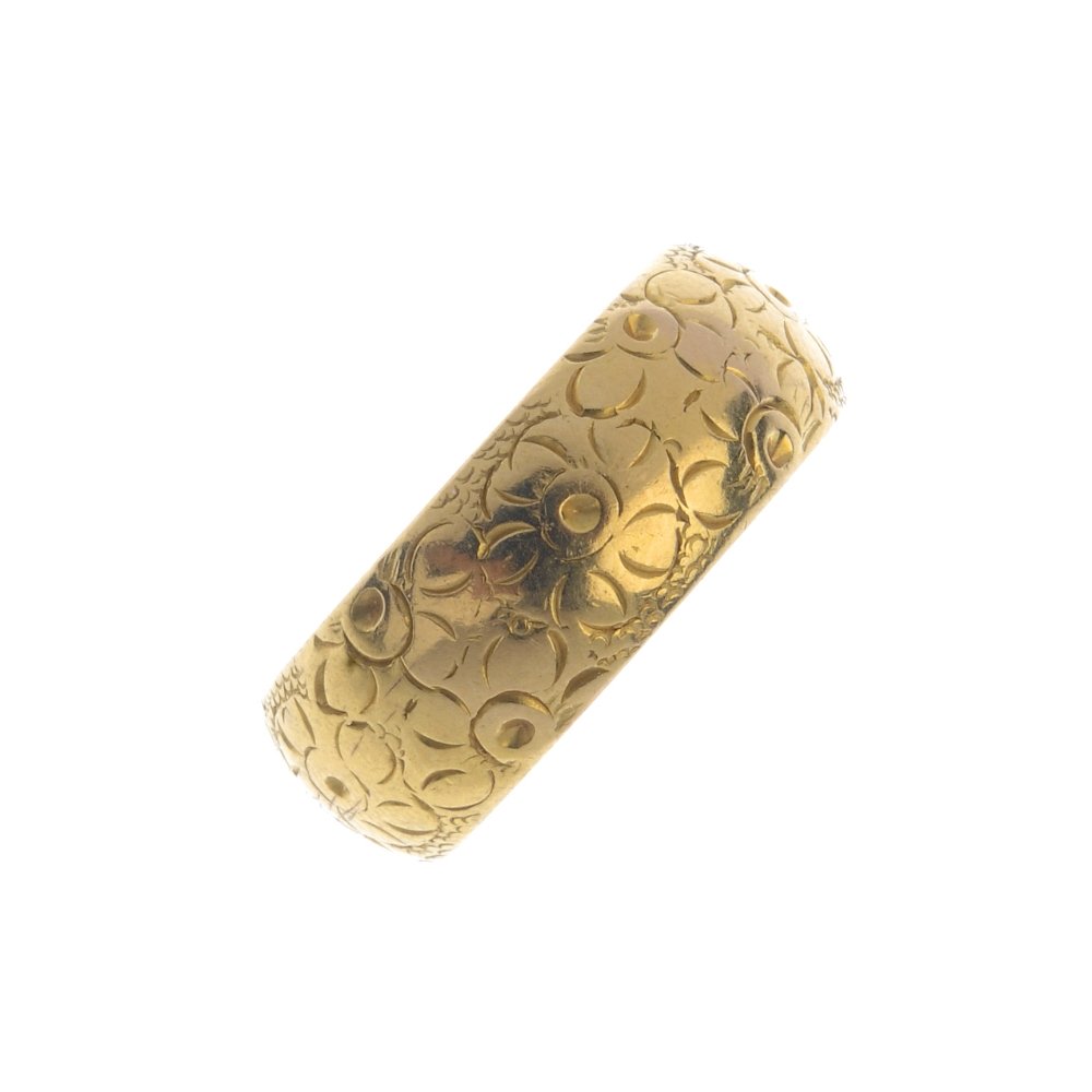 A 1960s 22ct gold band ring. With engraved floral (1 of 3)