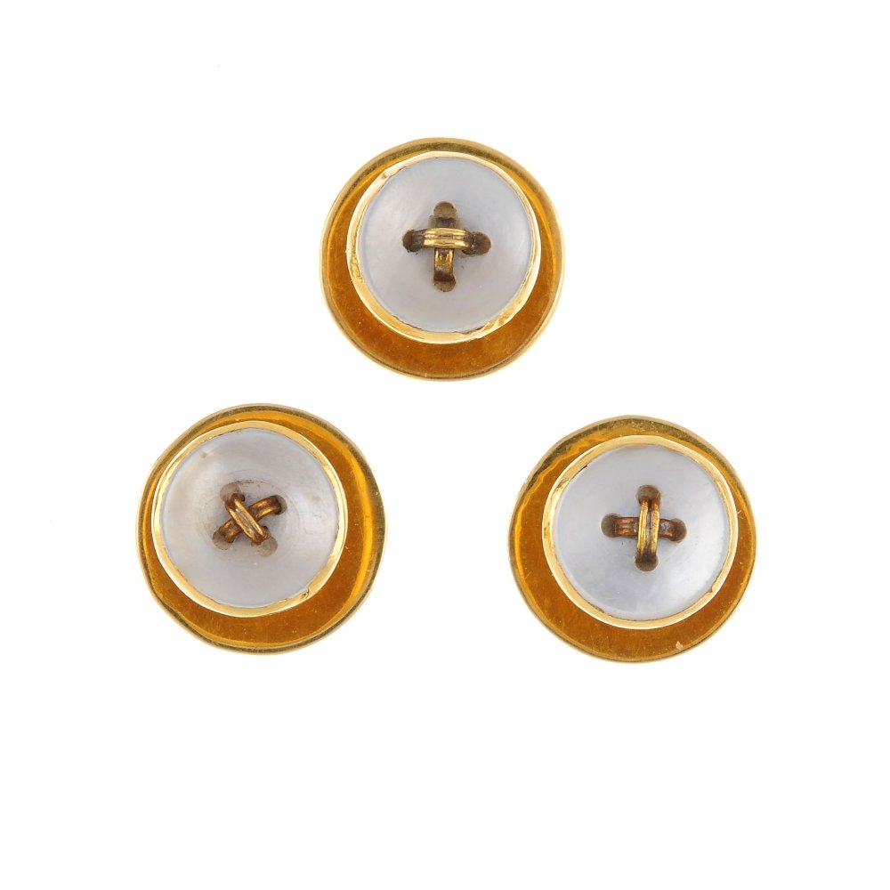 A set of three early 20th century 18ct gold: A set of three early 20th century 18ct gold mother-of-pearl dress studs. Each designed as a mother-of-pearl 'button' with central gold thread cross. Diameter of stud face 0.8cm. Weight 4gms. Overall c
