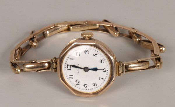 ROLEX - 1930's 9ct gold ladies watch with a shape: ROLEX - 1930's 9ct gold ladies watch with a shaped circular white dial with black Arabic numerals, the manual wind movement marked Rolex, 15 jewels, timed six positions for all climates fitted on a 9c