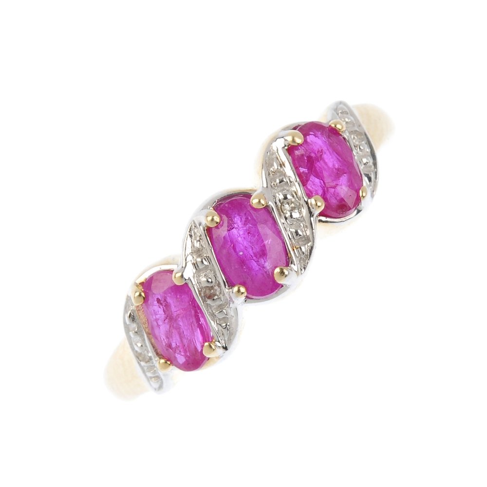 A 9ct gold ruby three-stone ring. The oval-shape ruby (1 of 3)