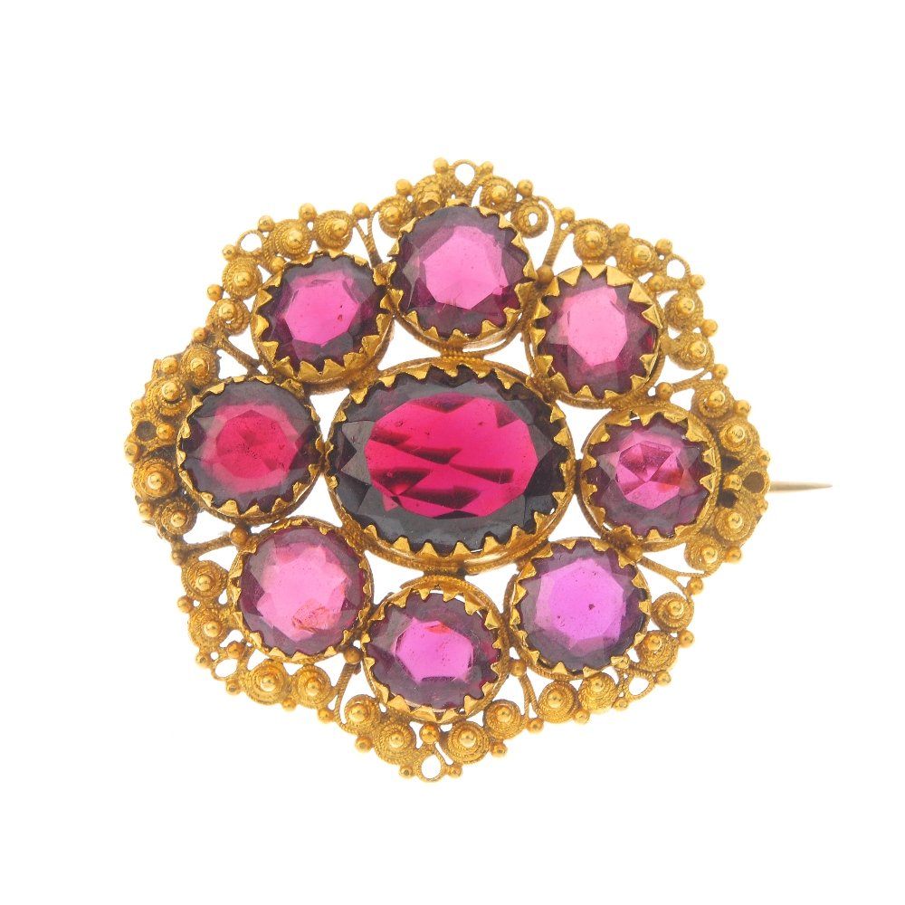 A garnet brooch. The oval-shape garnet, within a (1 of 3)