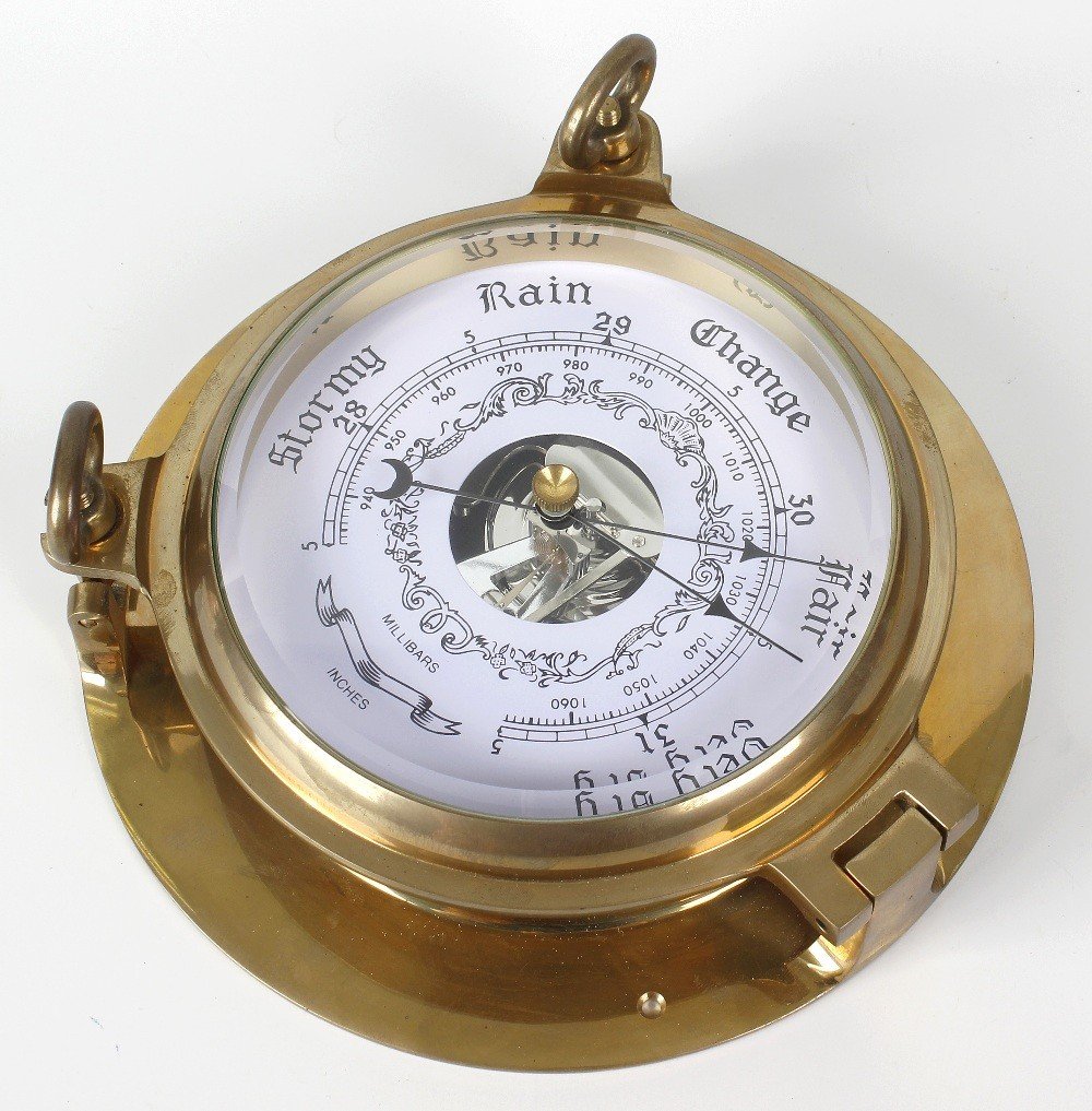 A box containing a Comitti mahogany veneered: A box containing a Comitti mahogany veneered reproduction Banjo shaped wall hanging barometer, reproduction brass cased ships style bulkhead clock and barometer, and a mixed selection of modern alarm