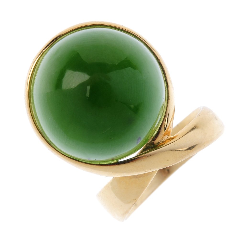 OLE LYNGGAARD - a 1970s Danish 14ct gold nephrite jade: OLE LYNGGAARD - a 1970s Danish 14ct gold nephrite jade ring. The circular nephrite jade cabochon, off-set in a crossover mount to the slightly tapered band. Maker's marks for Ole Lynggaard. Import mar
