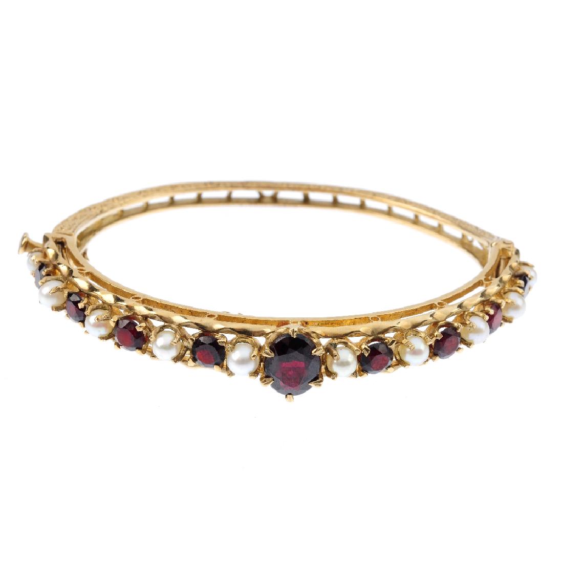 A 9ct gold garnet and cultured pearl hinged bangle. The (1 of 3)