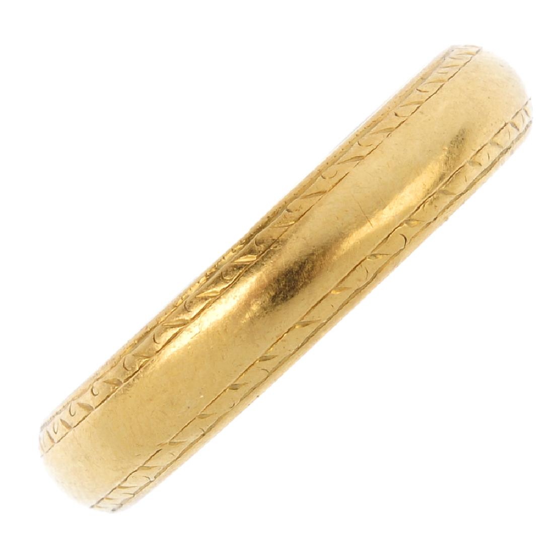An 18ct gold band ring. Designed as a band, with (1 of 2)