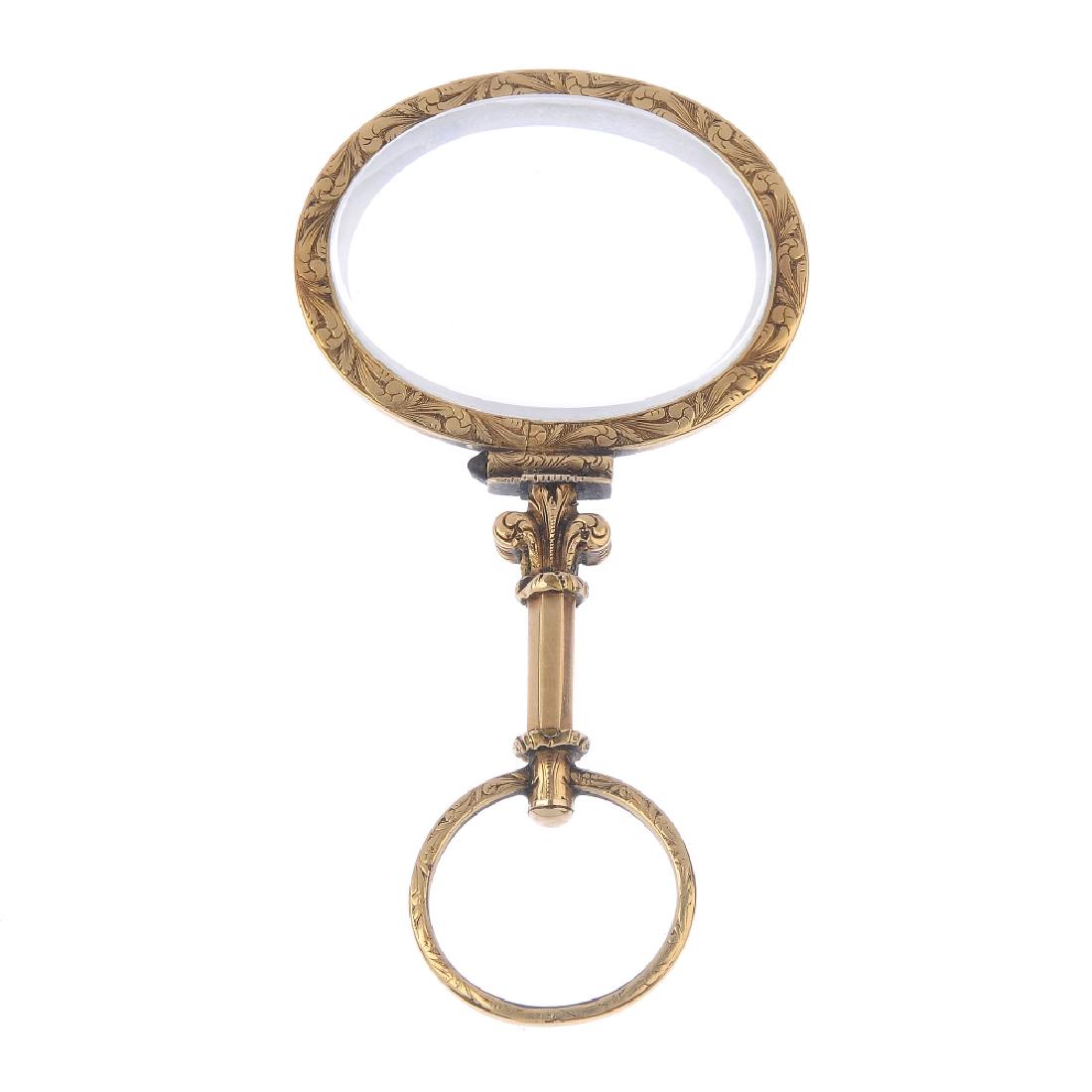 An early Victorian magnifying glass, circa 1840. The: An early Victorian magnifying glass, circa 1840. The oval-shape faceted lense, with scroll engraved surround and handle. Length 7.3cms.