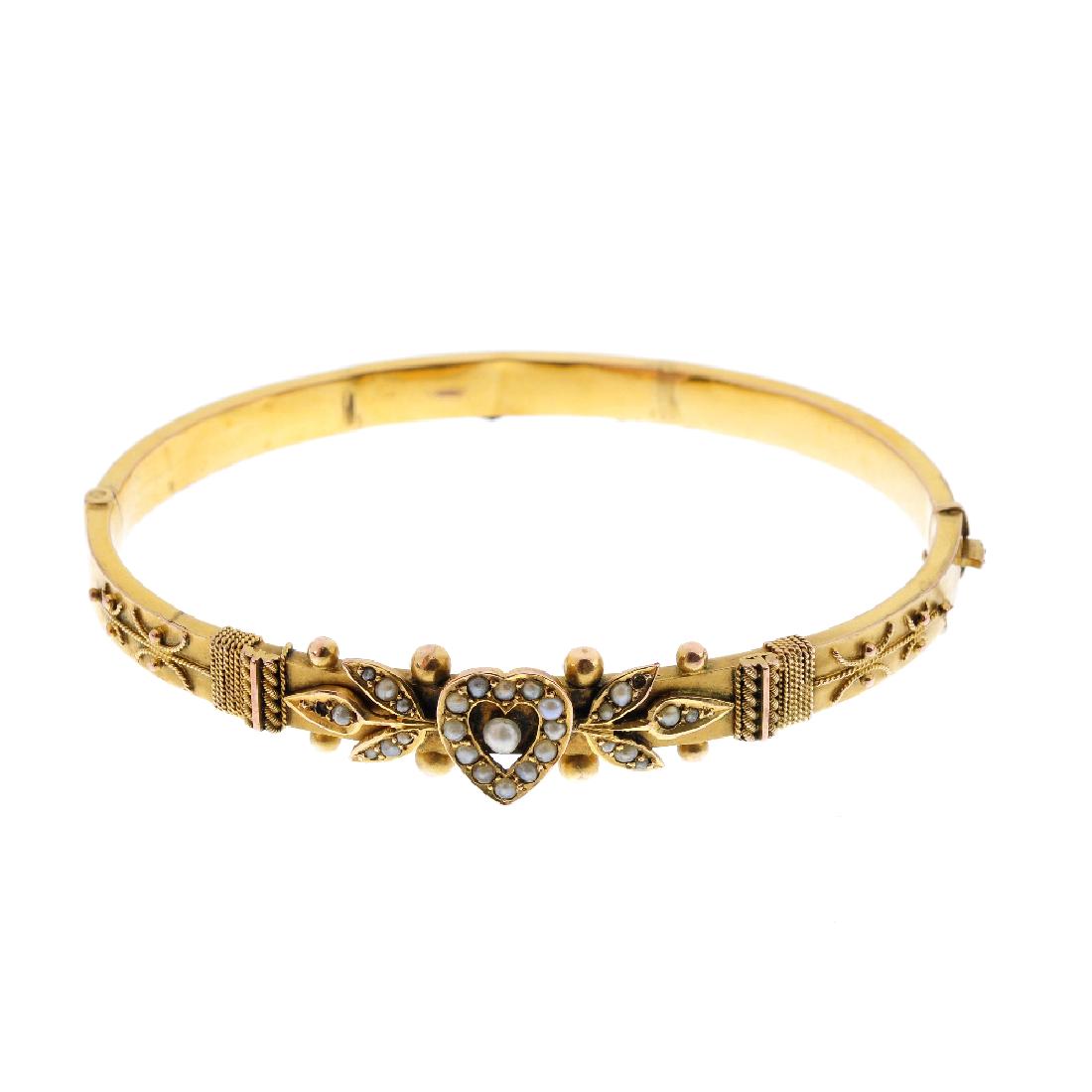 An Edwardian 9ct gold split pearl hinged bangle. The (1 of 2)